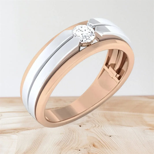 Two-tone gold ring with a diamond on a light wooden surface
