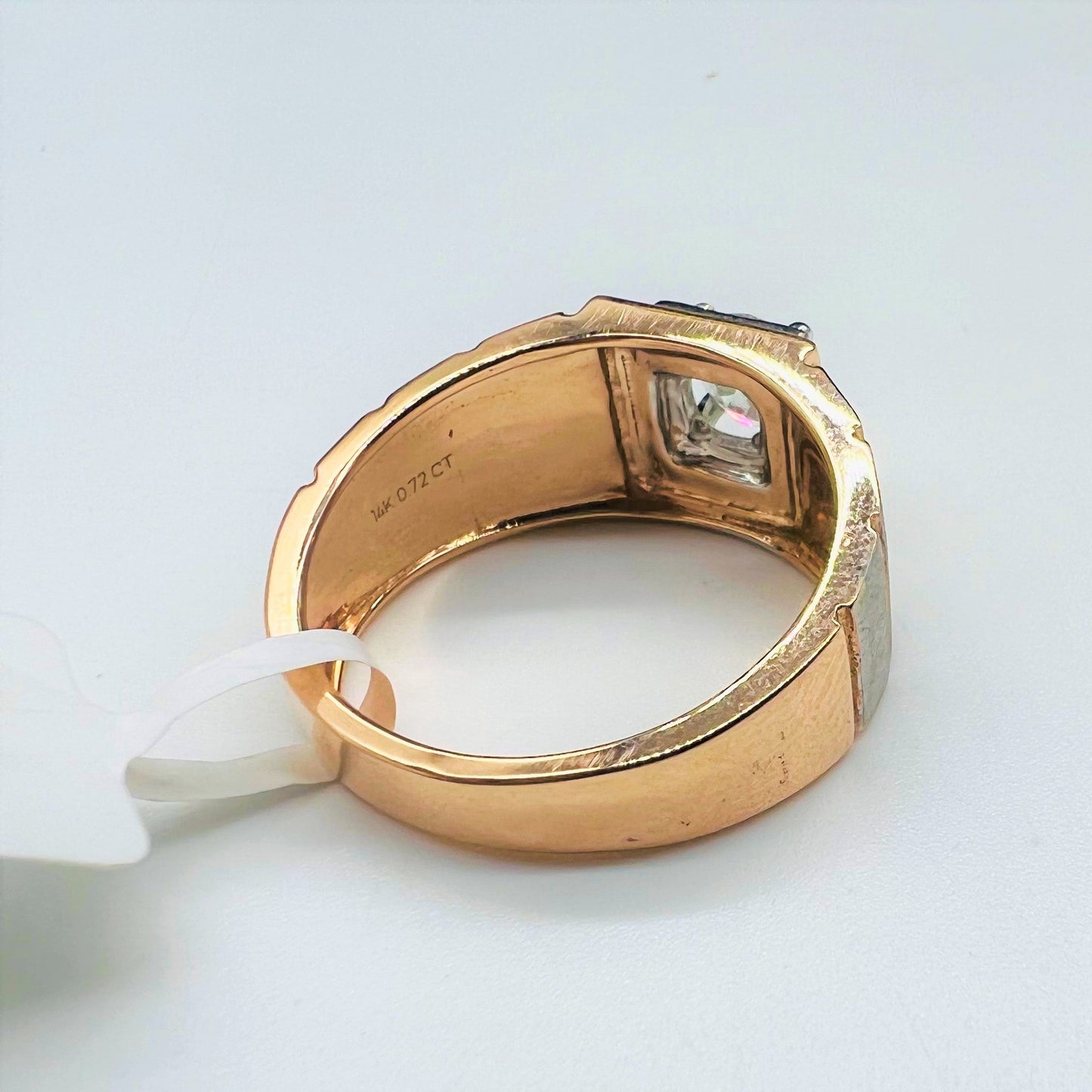 A solitaire diamond ring with a gold band displayed on a white surface.