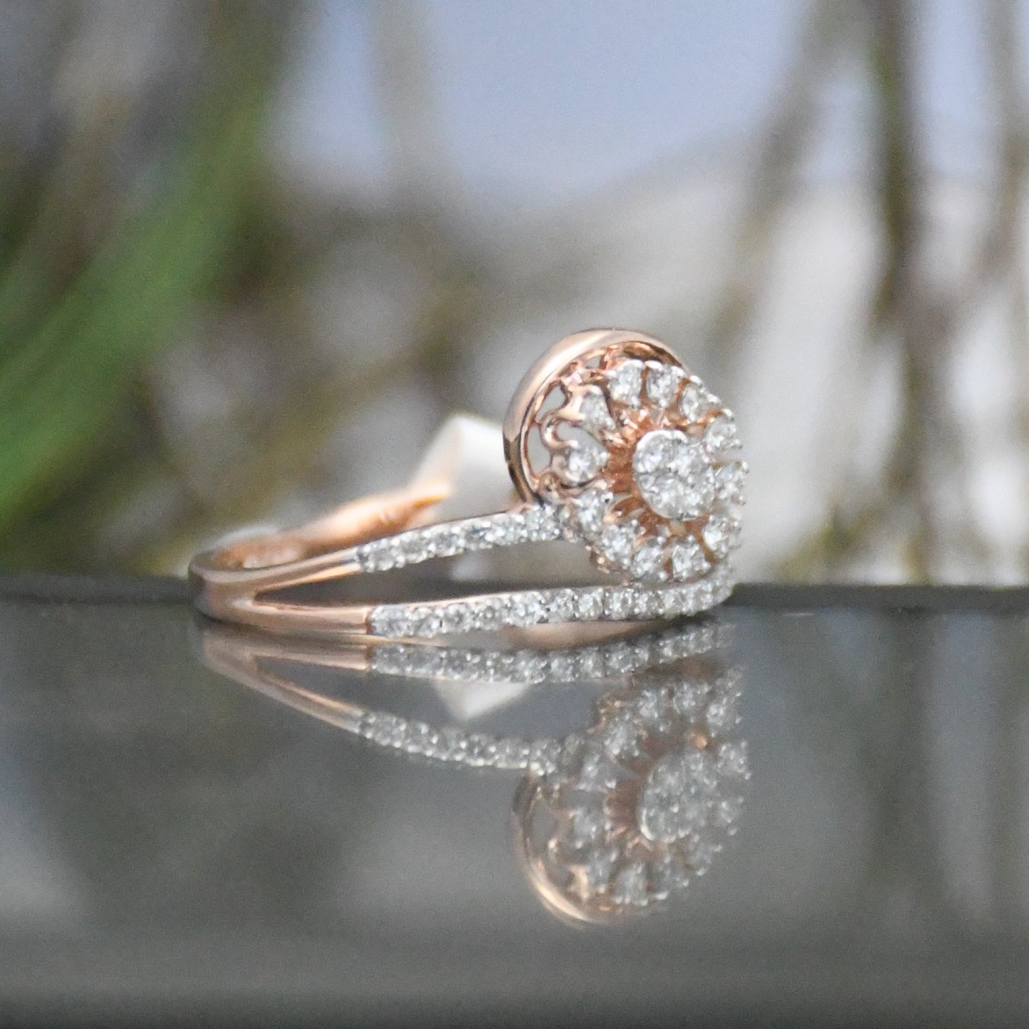 Rose gold ring with diamond accents on a reflective surface