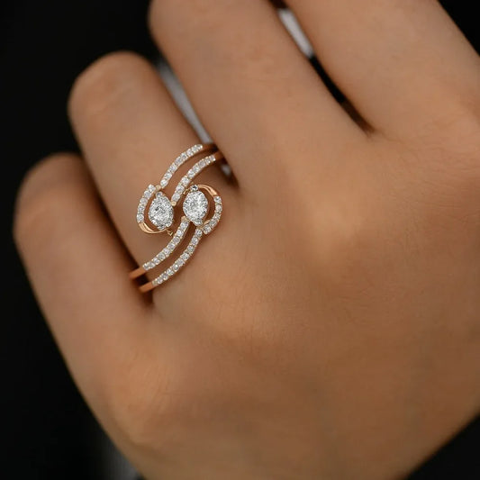 Rose gold ring with diamonds on a hand against a dark background