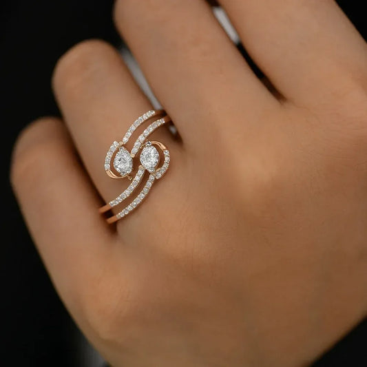 Rose gold ring with diamonds on a hand against a dark background