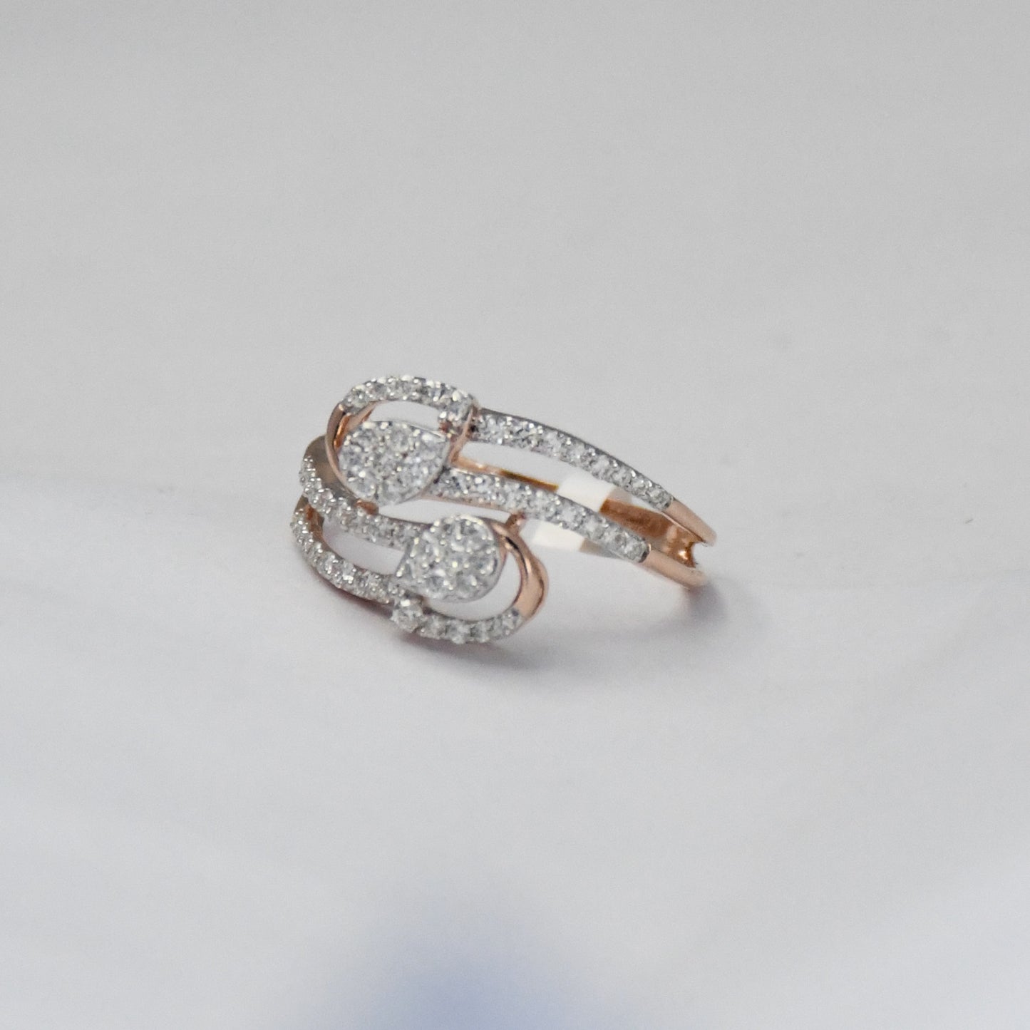 Rose gold ring with diamonds on a light gray background