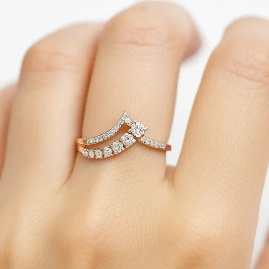 Rose gold ring with diamonds on a finger against a white background