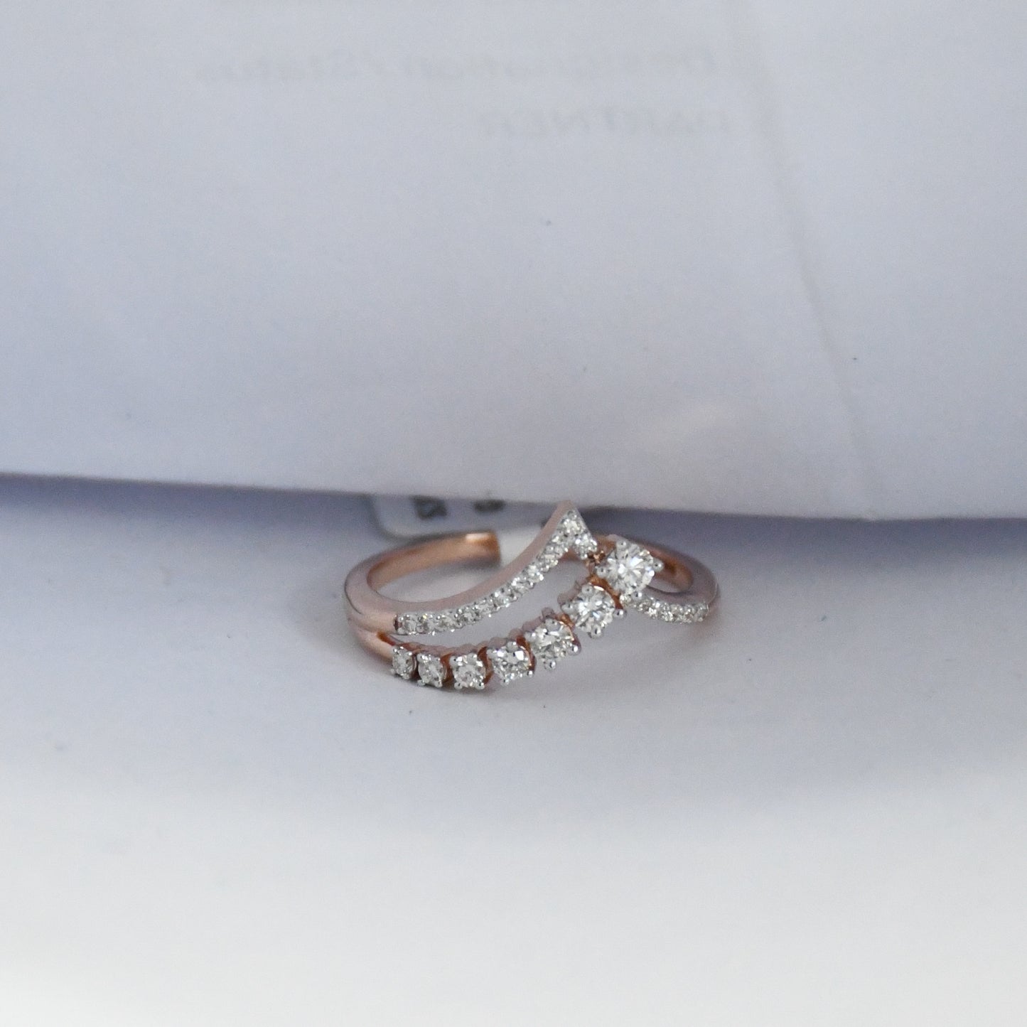 Rose gold ring with diamonds on a white background