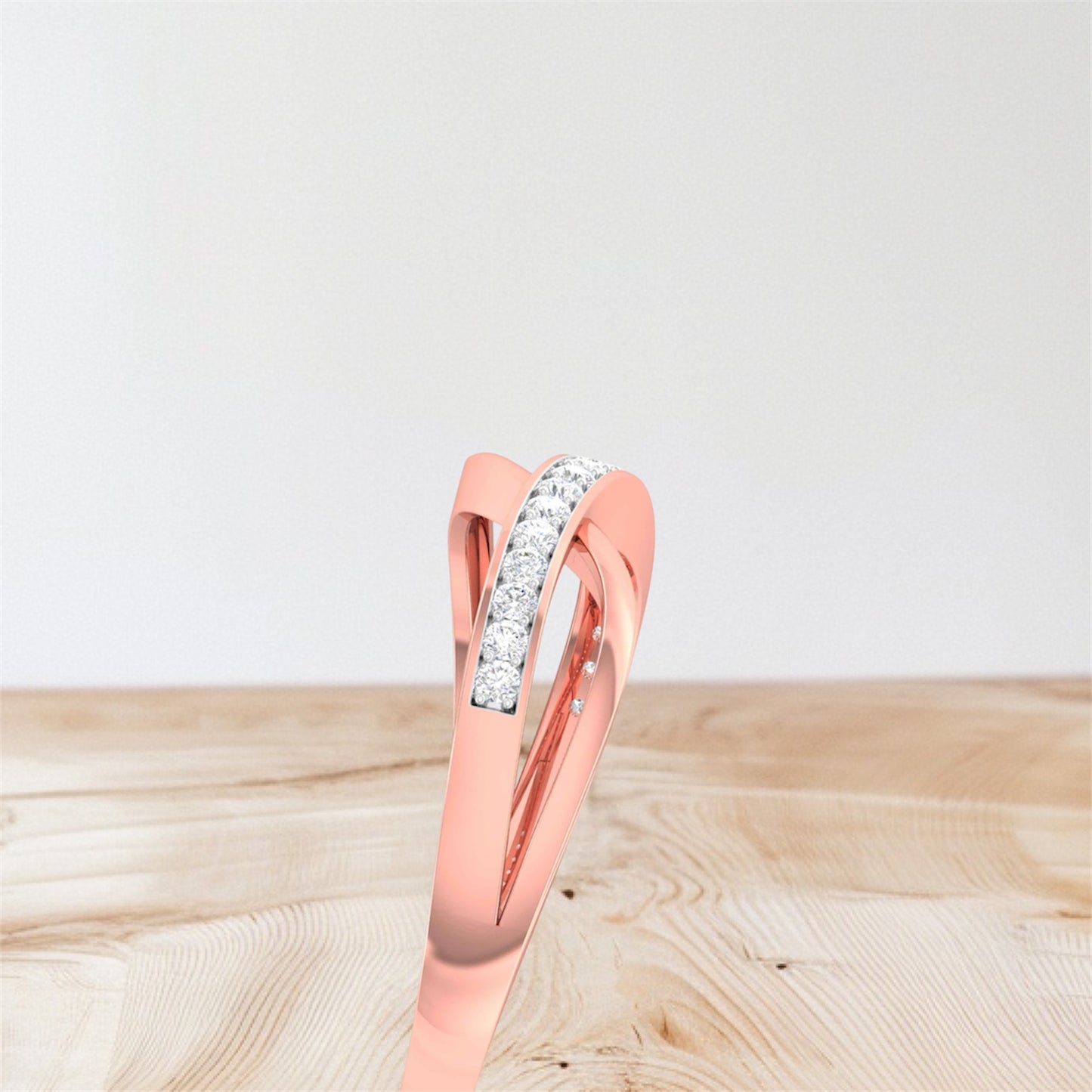 Rose gold ring with diamonds on a wooden surface