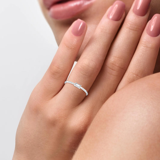 Close-up of a hand wearing a gold diamond ring with a white background