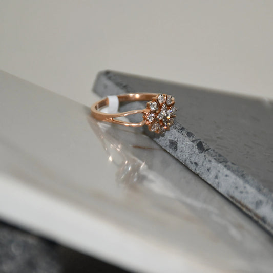 A 14kt gold band ring with a round brilliant cut diamond centerpiece, set on polished and unpolished stones.