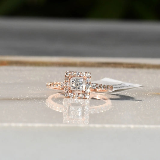 A 14K gold ring with a central square-shaped setting holding a sparkling, multicolored diamond, surrounded by smaller round diamonds set in a polished, reflective surface.