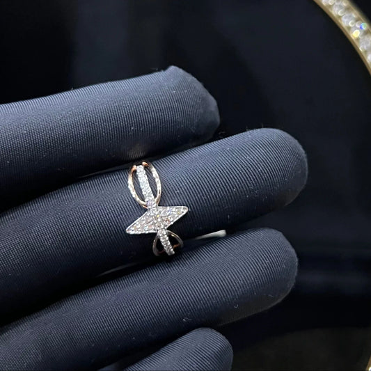 A handcrafted natural diamond solid gold ring, held in a gloved hand, featuring a brilliant cut diamond on a band with a star-shaped detail on the top.