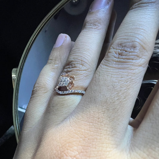 A person's hand displaying a gold band ring with a central natural diamond, surrounded by smaller clear stones.