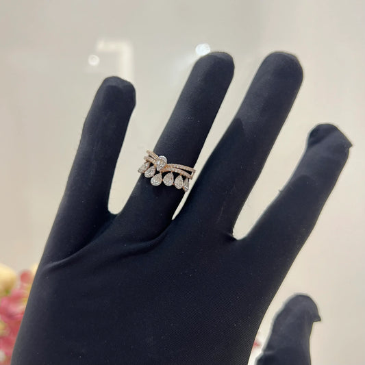 Close-up of a hand holding a crown-inspired diamond ring featuring multiple baguette-shaped diamonds set upright along the top, paired with a pavé-set band in gold.