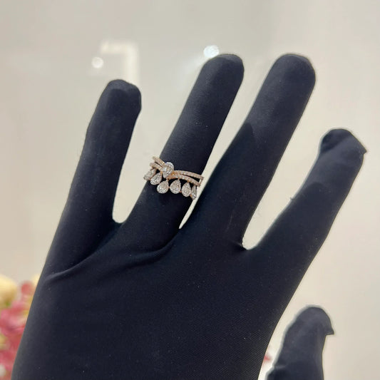Close-up of a hand holding a crown-inspired diamond ring featuring multiple baguette-shaped diamonds set upright along the top, paired with a pavΓ©-set band in gold.