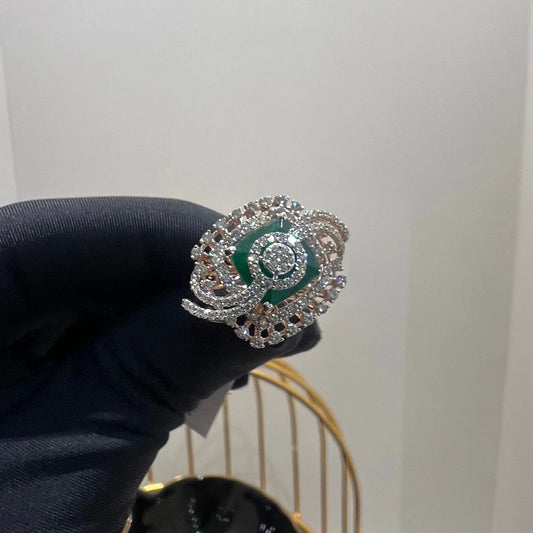 A handcrafted natural diamond solid gold ring held in a person's hand, with a green gemstone and intricate gold detailing.