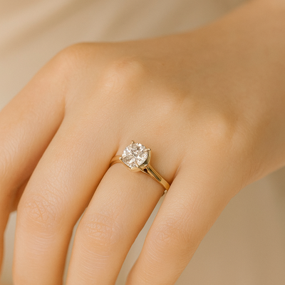 A classic solitaire lab grown diamond ring with a round-cut diamond set in a four-prong gold band.