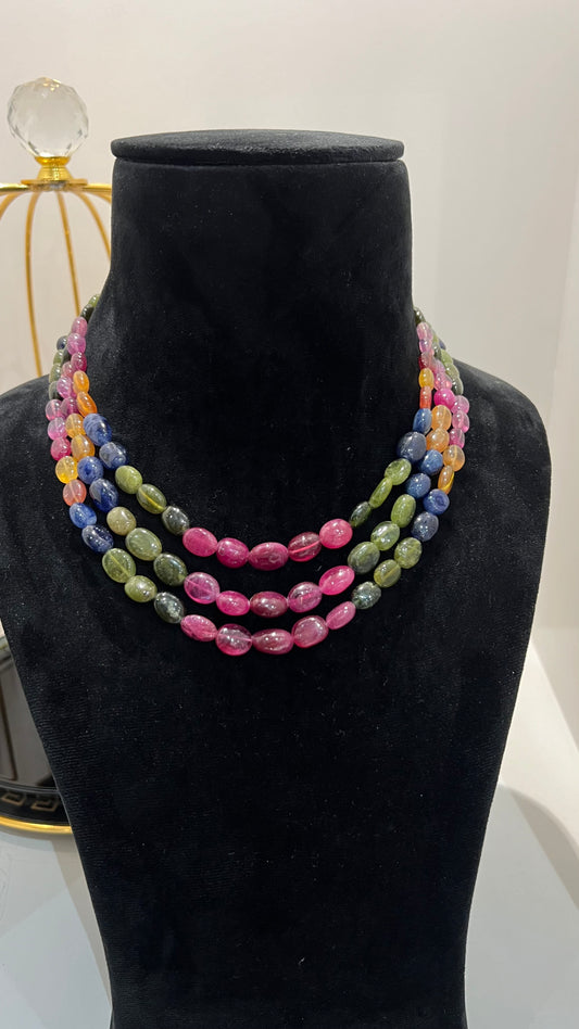 A multi-color beaded necklace displayed on a mannequin, featuring multiple strands and an adjustable dori.