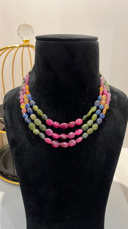 A multi-color beaded necklace displayed on a mannequin, featuring multiple strands and an adjustable dori.
