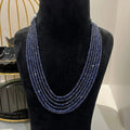 A multi-strand 6 layer blue sapphire beads necklace displayed on a black mannequin bust.