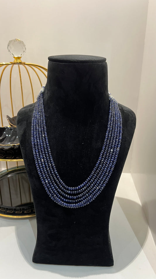 A multi-strand 6 layer blue sapphire beads necklace displayed on a black mannequin bust.