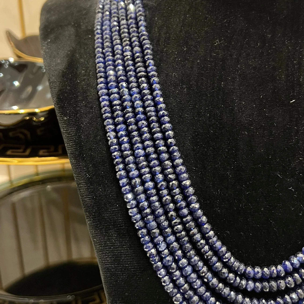 A multi-strand 6 layer blue sapphire beads necklace displayed on a black mannequin bust.
