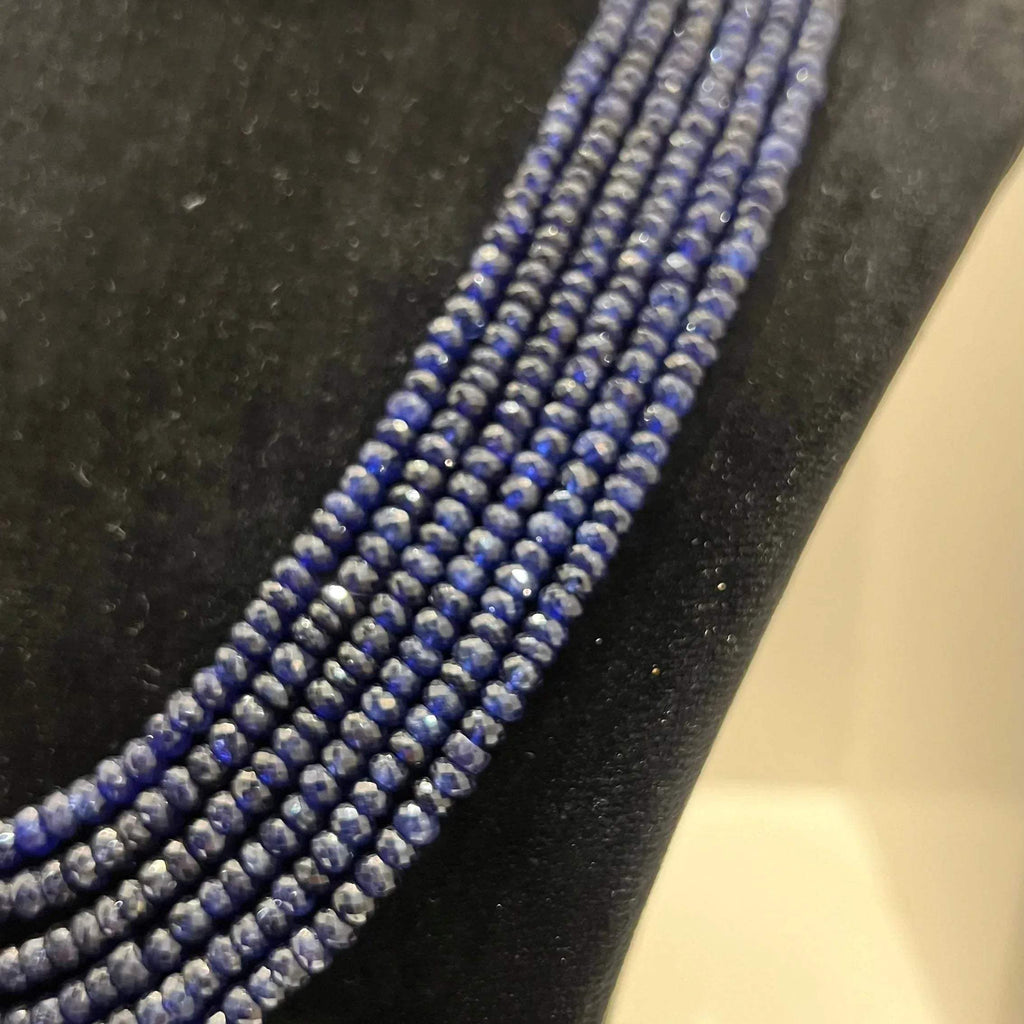 A multi-strand 6 layer blue sapphire beads necklace displayed on a black mannequin bust.