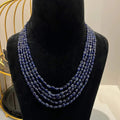 A multi-strand 5 layer blue sapphire beads necklace displayed on a mannequinnecklace stand.