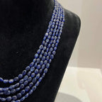 A multi-strand 5 layer blue sapphire beads necklace displayed on a mannequinnecklace stand.