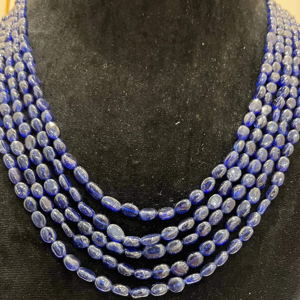A multi-strand 5 layer blue sapphire beads necklace displayed on a mannequinnecklace stand.
