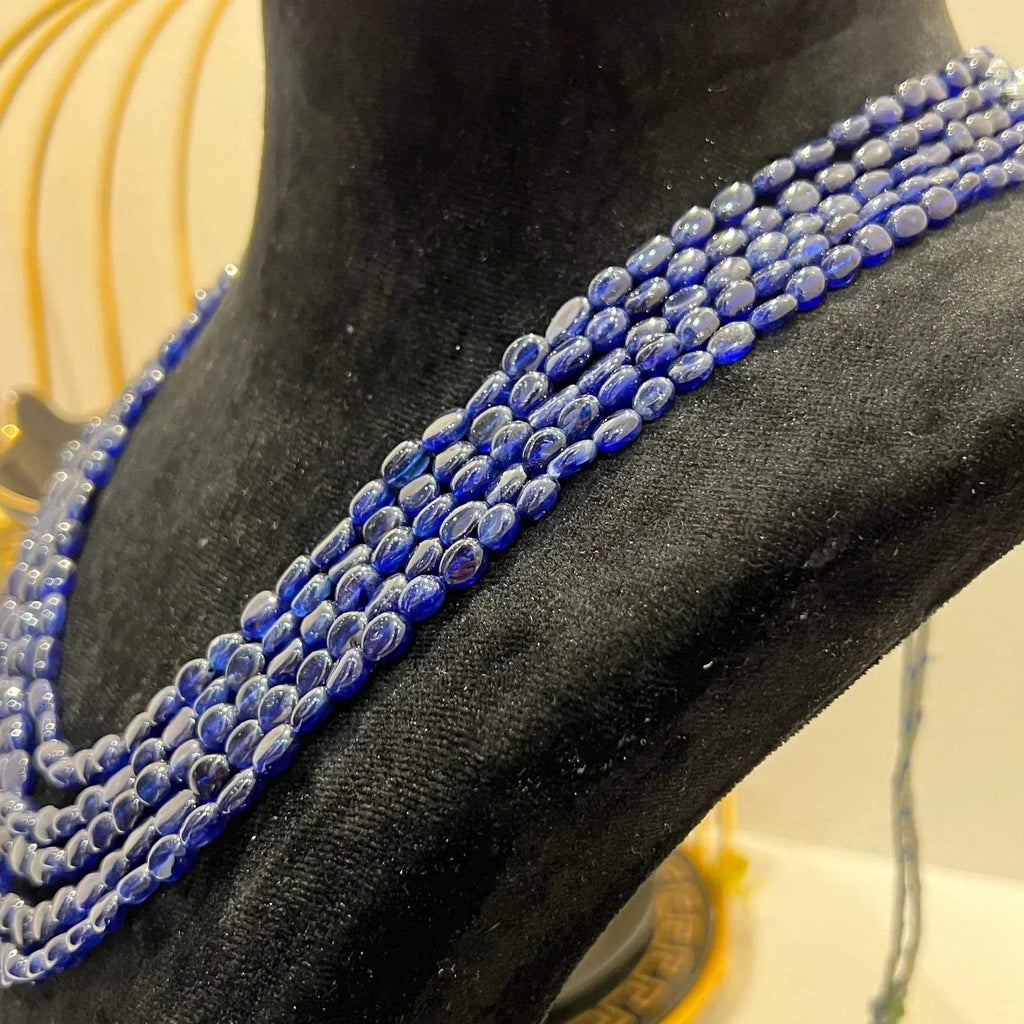 A multi-strand 5 layer blue sapphire beads necklace displayed on a mannequinnecklace stand.