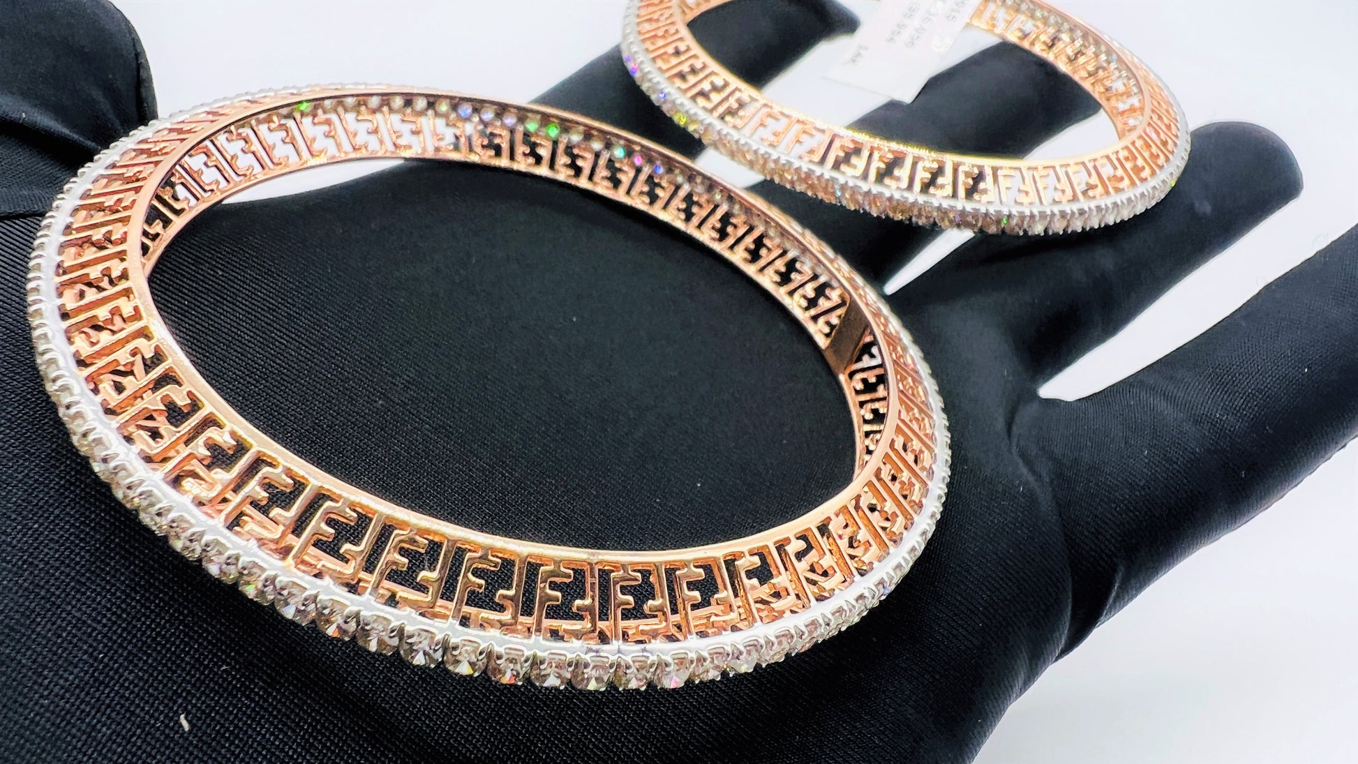 Side view of rose gold diamond bangle set featuring fine diamond lining and modern cutwork design in 14k gold.