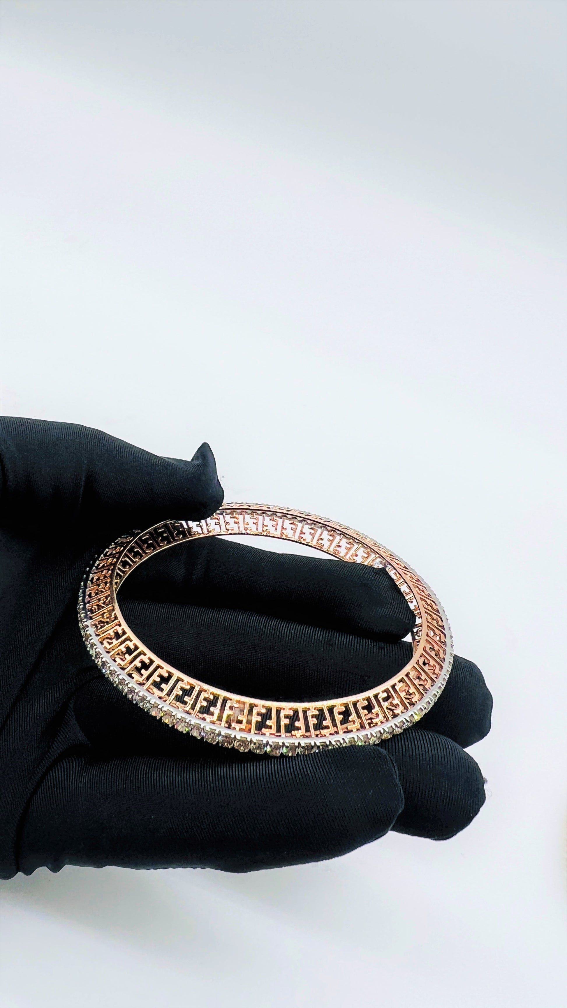 Zoom out view of rose gold diamond bangle set featuring fine diamond lining and modern cutwork design in 14k gold.