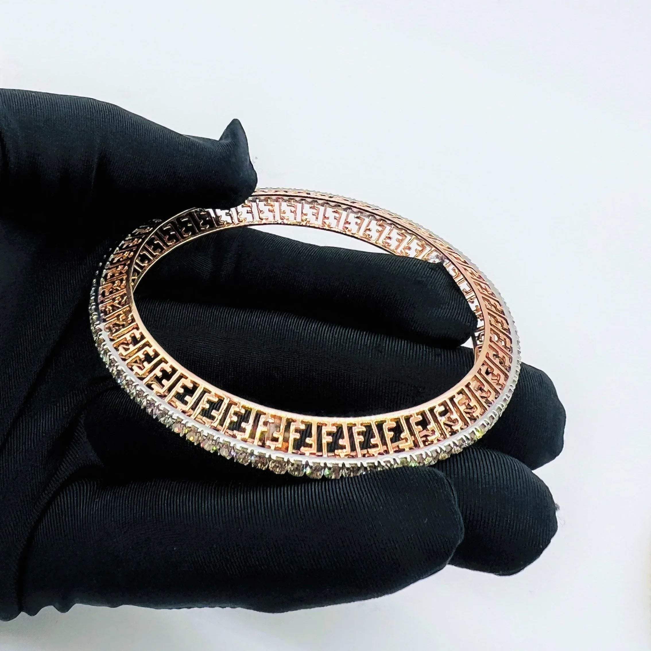 Zoom out view of rose gold diamond bangle set featuring fine diamond lining and modern cutwork design in 14k gold.