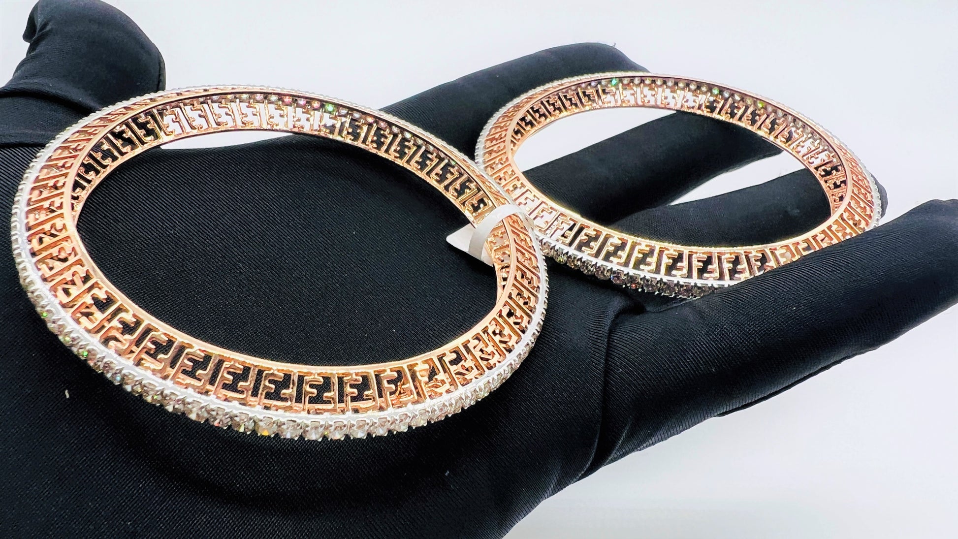 Side view of rose gold diamond bangle set featuring fine diamond lining and modern cutwork design in 14k gold.