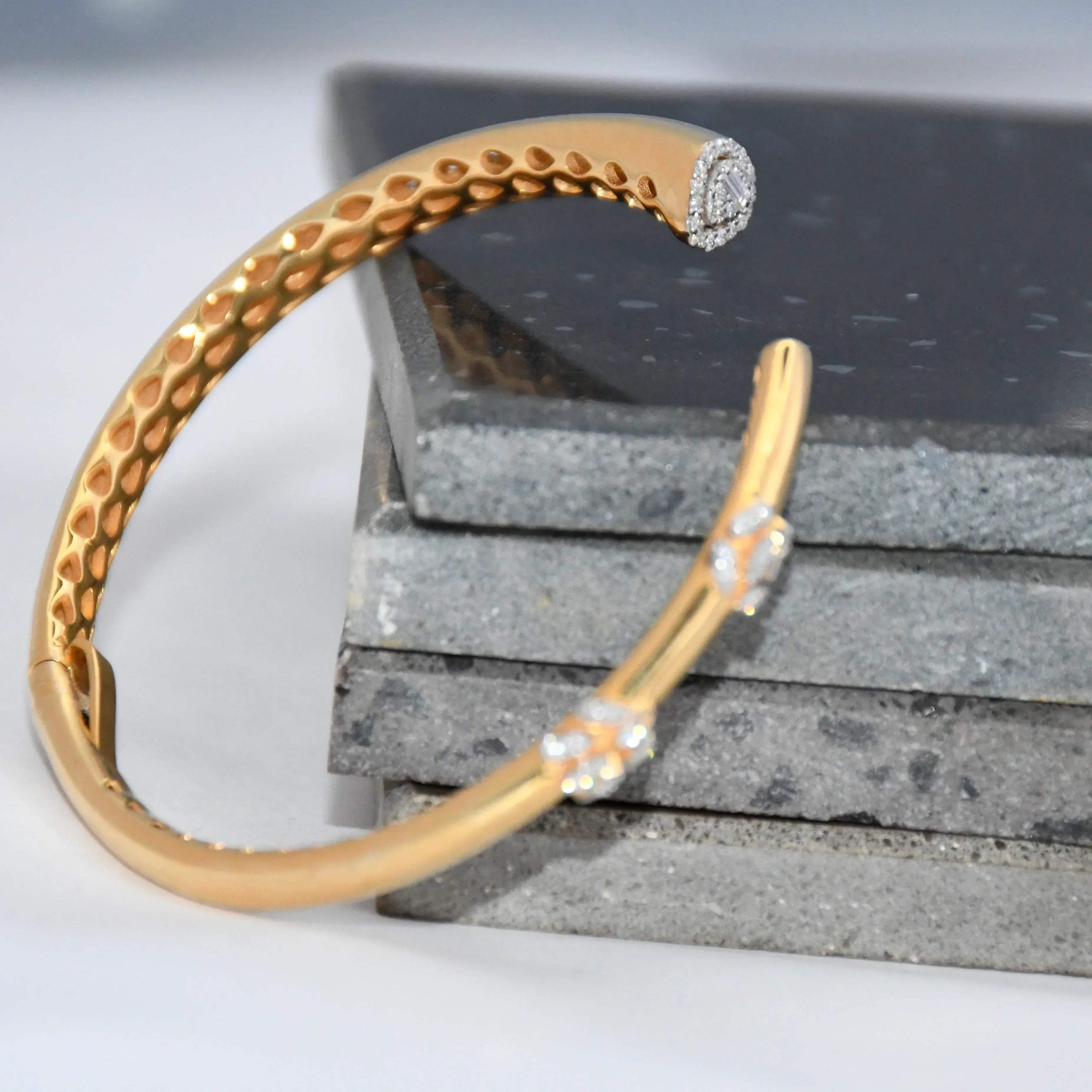 Gold bracelet with real diamond accents on a textured surface