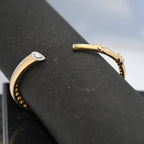 Gold bracelet with real diamond accents on a black surface
