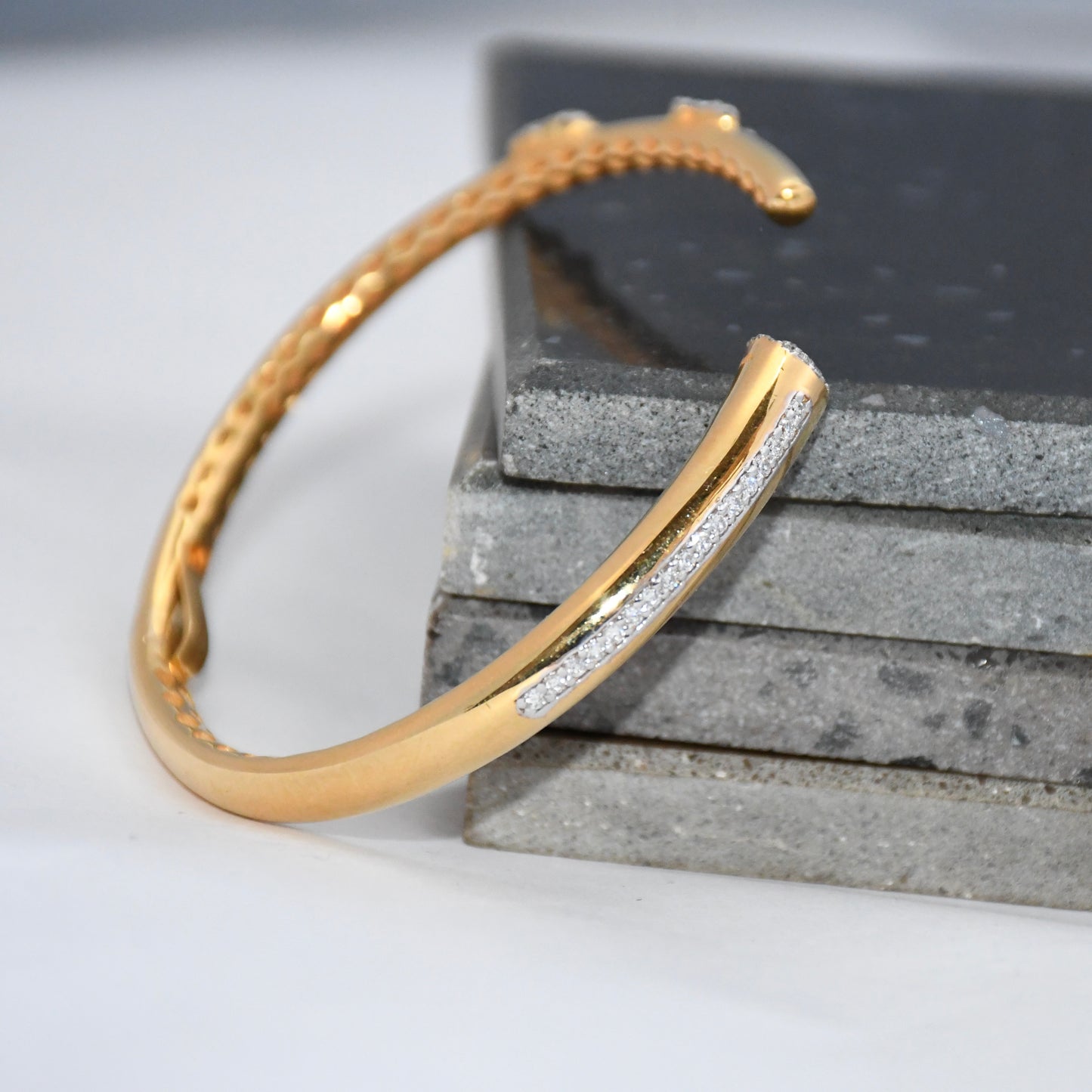 Gold bracelet with real diamonds on a textured surface