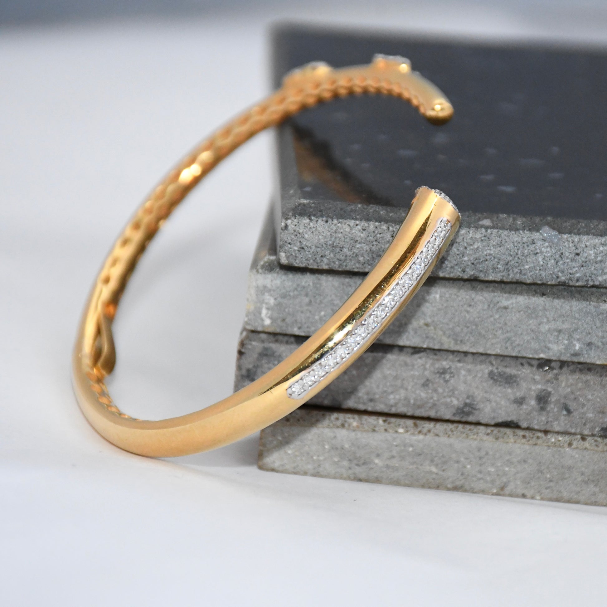 Gold bracelet with real diamonds on a textured surface