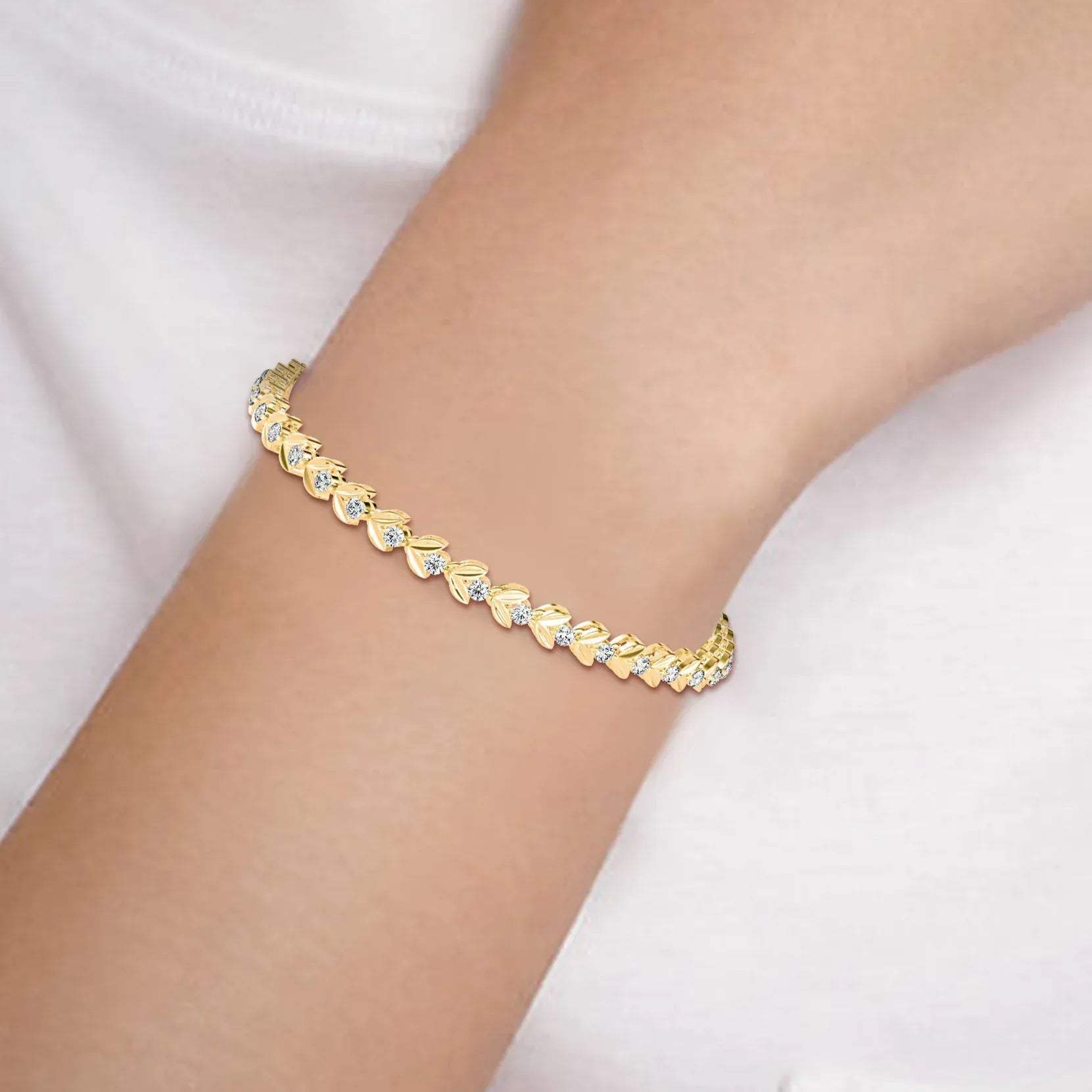 Gold diamond bracelet on a person's wrist with a white background