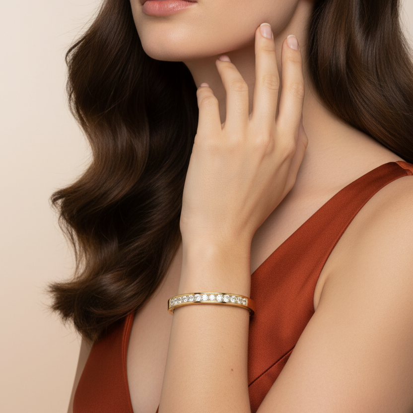 Woman wearing a gold and real diamond bracelet with a beige background