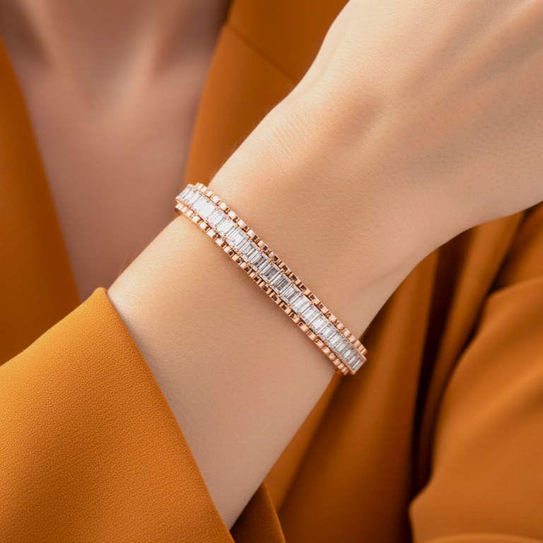 Rose gold bracelet with real diamonds on a wrist against an orange background