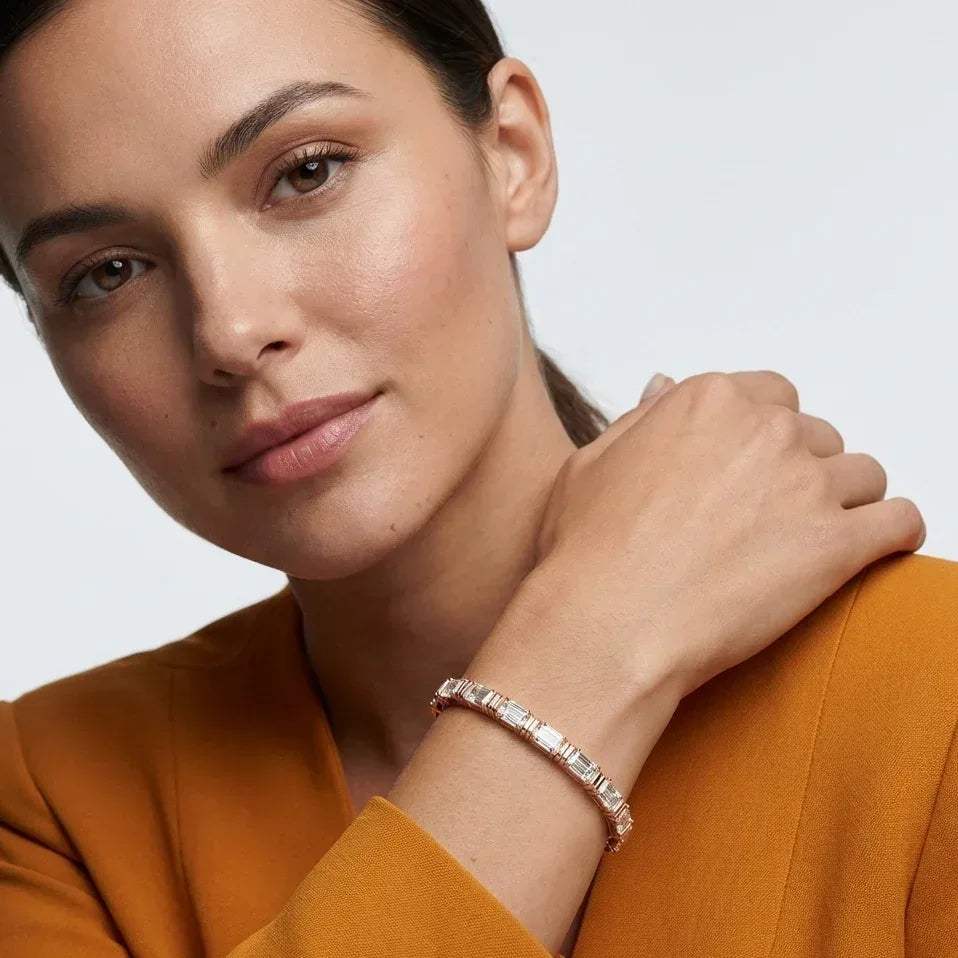 Woman wearing a real diamond tennis bracelet with a neutral background