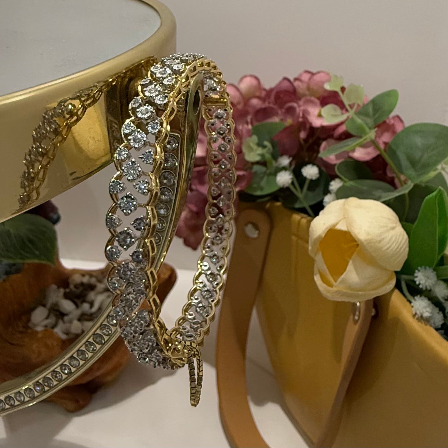 A luxurious diamond gold tennis bracelet with openable sections, featuring gold color and adorned with genuine diamonds, displayed on a stand.