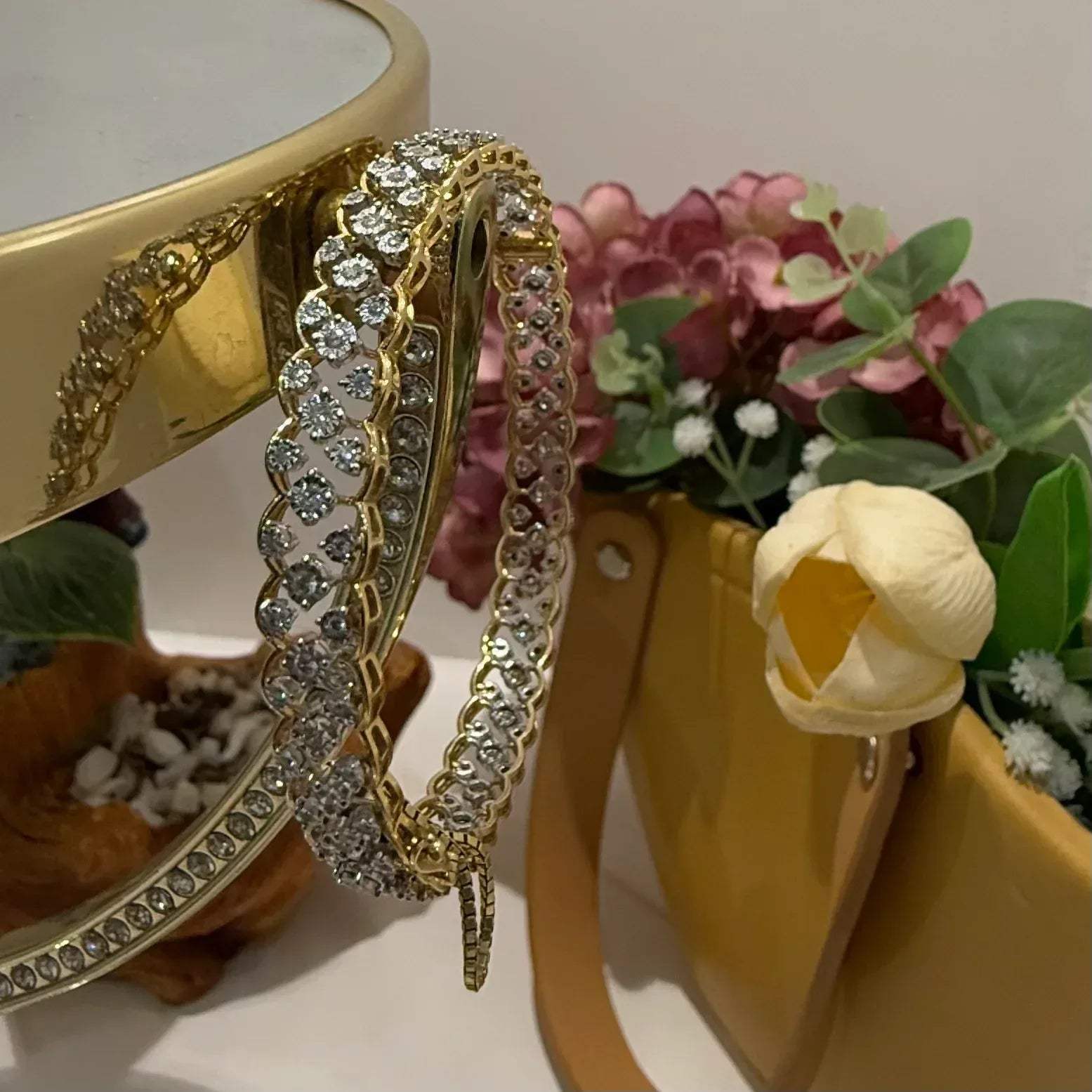A luxurious diamond gold tennis bracelet with openable sections, featuring gold color and adorned with genuine diamonds, displayed on a stand.