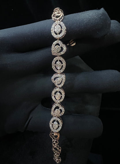 A gold diamond bracelet with oval heart shapes, displayed on a black mannequin hand.