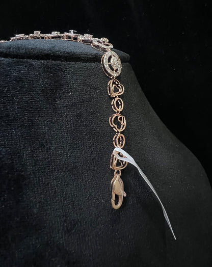 A gold diamond bracelet with oval heart shapes, displayed on a black mannequin.