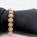 A gold diamond bracelet with multiple rows of inset stones, displayed on a mannequin hand.