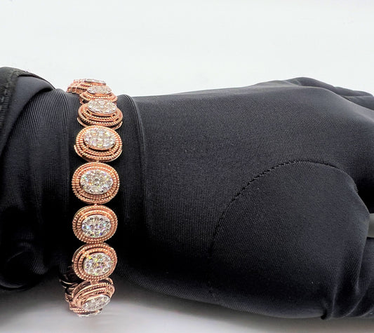 A gold diamond bracelet with multiple rows of inset stones, displayed on a mannequin hand.