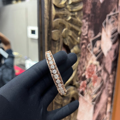 Elegant gold diamond bracelet with round-cut diamonds in a bangle design, displayed on a hand.