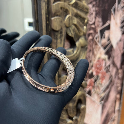 Elegant rose gold diamond bracelet with round-cut diamonds in a bangle design, displayed on a hand.