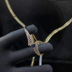 A luxurious gold diamond bracelet with a brilliant cut blue stone in an openable design, displayed by a hand.
