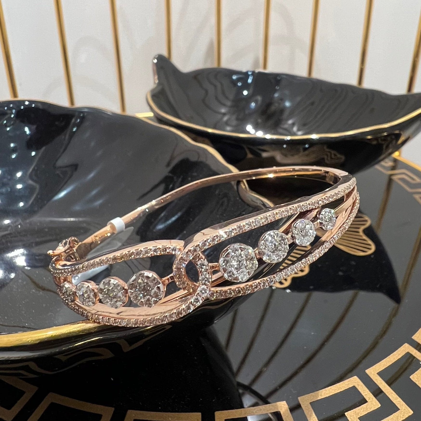 Gold diamond bracelet with round brilliant cut diamonds in chain-link bangle design displayed on luxury background.
